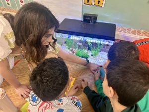 teacher shows students fish in the classroom